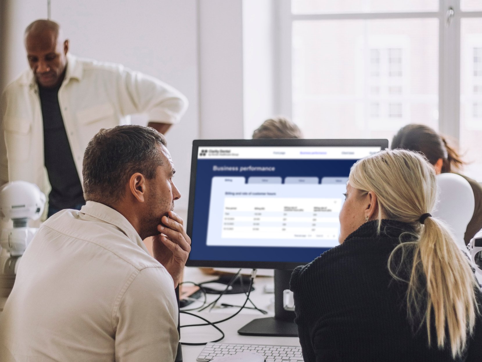 21_office_workers_looking_at_solutions_report_screen_horizontal